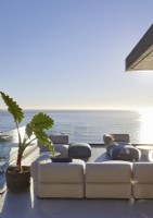 Canapés sur terrasse dans un grand salon extérieur avec vue sur la mer