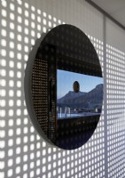 Détail de miroir circulaire avec réflexion montrant l'espace de vie extérieur