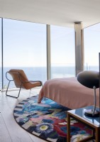 Tapis circulaire vibrant dans une chambre contemporaine avec vue sur la mer