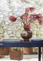 Vase de fleurs tropicales coupées rouges dans un vase sur une table en bois