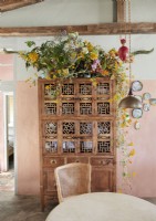 Armoire en bois vintage ornée avec un grand arrangement de fleurs