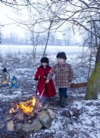 Petit frère et soeur rôtir des guimauves sur feu ouvert le jour de Noël