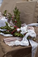 Détail du cadeau de Noël emballé avec ruban, baies et neige