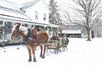 Ferme Amish vintage dans la neige avec mère et enfants en traîneau tiré par un cheval belge.
