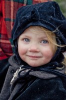Petite fille vêtue d'un chapeau et d'un manteau d'hiver pour une promenade en traîneau à Noël