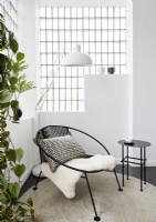 Petite chaise moderne noire et table d'appoint dans un salon moderne blanc