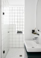 Salle de bain en carrelage blanc avec lavabo vert et blanc