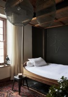 Petit lit à baldaquin en pays chambre avec mur peint en noir