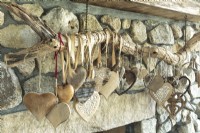 Une collection de cœurs uniques recueillis lors de voyages lointains occupe le devant de la scène sur la cheminée en pierre.