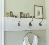 Les crochets, comme ces patères vintage de style école, offrent un espace de rangement supplémentaire dans une petite chambre.