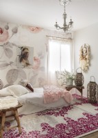 Un papier peint à motif de roses, un attrape-rêves et un tapis de style tapisserie apportent une ambiance bohème romantique à la chambre d'amis.a