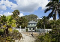 L'extérieur du cottage vintage classique de Floride a été peint en vert pâle avec des garnitures blanches contrastantes pour refléter le feuillage local et la plage de sable.