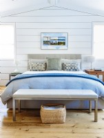Le lit rembourré moderne de couleur neutre répond à la préférence de Linda pour une direction épurée et contemporaine. La literie bleue et blanche fraîche contribue au sentiment serein de calme et d'élégance de l'espace.
