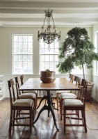 La lumière naturelle baigne la salle à manger de campagne, qui est simplement mais élégamment meublée avec des chaises vintage préférées et une grande table ancienne.