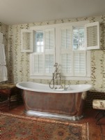 Pour satisfaire un désir sérieux d'une salle de bain principale glorieuse, Ellen a sculpté l'espace d'une chambre adjacente pour adapter et mettre en valeur cette baignoire de trempage profonde et ancienne de style anglais façonnée en étain poli et en porcelaine.
