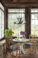 La lumière jaillit de nombreuses fenêtres pour remplir le salon, autrefois un ancien porche en brique abritant des orchidées en hiver. La table d'angle confortable offre un endroit tranquille pour le petit déjeuner ou le thé pour deux.