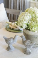 Une jardinière en pierre et des oiseaux apportent un peu de jardin à la table de la salle à manger.
