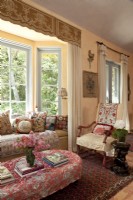 Un siège de fenêtre invitant et une chaise française recouverte de housse sont situés au cœur de la grande salle. Un défilé d'oreillers chics présente une mini-histoire de l'art textile.