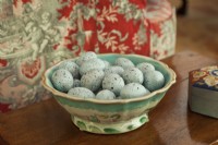 Un bol en majolique antique dorlote des œufs bleus célestes.