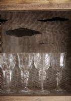 Détail de verres à vin sur étagère soutenu par sac de jute