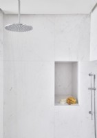 Cabine de douche en marbre blanc avec étagère en alcôve