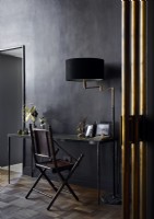 Bureau et chaise classiques avec murs peints en noir et accessoires dorés