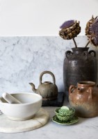 Couper les fleurs d'artichaut dans un pot en céramique sur le plan de travail de la cuisine