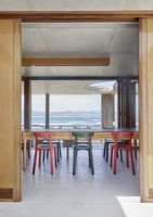 Chaises colorées dans une salle à manger contemporaine avec vue sur la côte