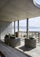 Sièges intégrés en béton sur un balcon moderne avec vue sur la mer
