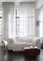 Canapé blanc et tissus d'ameublement sur canapé devant la fenêtre