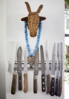 Détail de couteaux sur bande magnétique murale avec ornement de taureau de paille