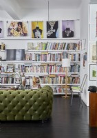 Canapé vert classique dans un salon moderne avec mur de bibliothèque
