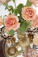 Roses sur un plateau en verre avec ornements en laiton
