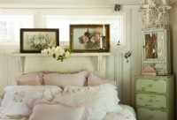 Un manteau de cheminée tourné vers la tête de lit offre une étagère pour les peintures vintage qui partagent les motifs et les teintes des draps.