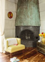 Le panneau de cheminée en cuivre a été «vieilli» pour contraster avec les nouveaux carreaux de mosaïque terreux.