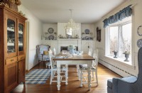 Un manteau de cheminée victorien, une table spacieuse, un buffet majestueux et un thème bleu et blanc définissent le confort de la ferme française de la salle à manger.