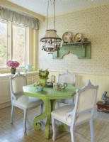 Inondé de charme champêtre, le coin petit-déjeuner est centré sur une table vert vif entourée de chaises de friperie.