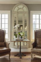 Plutôt que purement décoratif, la récupération architecturale a un sens dans cette maison. Remplacer le verre par un miroir dans les cadres de fenêtres et les portes françaises récupérés crée un intérêt pour la conception.