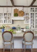 Lustres en cristal assortis, chaises de style Louis XVI, céramiques ferrugineuses anciennes et nouvelles, donnent le ton à la cuisine.