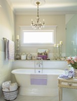 La salle de bain principale, avec sa baignoire autoportante, son lustre héritage et une gamme d'accents français, permet d'imaginer facilement que vous vous imprégnez de vos soucis en Provence