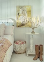 Installé sur une table récupérée, un candélabre vintage charme la chambre simple.