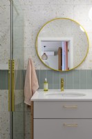 Salle de bain pastel avec grand miroir rond