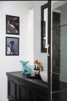 Vanité et œuvres d'art dans une salle de bain moderne en noir et blanc