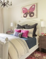 Un portrait de papillon a été l'inspiration pour la chambre d'amis. Le lit romantique en rotin blanc avec des détails sculptés à la main a un air résolument féminin.
