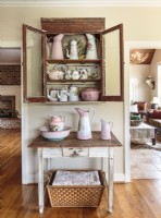 Avec des finitions brunes usées similaires, une armoire et une table modeste jouent le rôle de vaisselier et de huche.