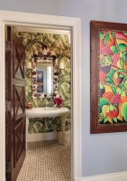 La nature entre par le biais du motif de papier peint à feuilles de bananier de la salle d'eau et d'une peinture colorée.
