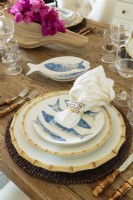 La table accueillante comprenait des chargeurs en rotin, de la porcelaine Classic Bamboo de Juliska, des bols à poisson en céramique et des ronds de serviette en coquillage.