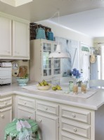 La simplicité est toujours à la mode. Dans ce cas, une cuisine entièrement blanche reçoit de petites touches de touches colorées et rustiques qui maintiennent l'ambiance légère et chaleureuse.