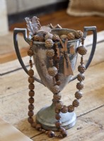 Des perles de chapelet en bois sculpté surdimensionnées débordent d'une tasse d'amour ternie.