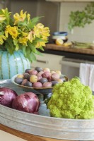 Lorsqu'un espace a une palette de couleurs neutres, même les éléments les plus ordinaires se démarquent, tels que des légumes vibrants nichés dans une cuve galvanisée.